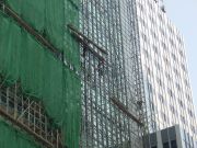Workers climb about on bamboo scaffolding