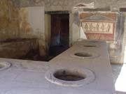 Inside a Roman shop. The holes in the counter would have been filled with fruits, vegetables, etc.