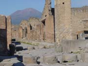 Street in Pompei and the volcano Vesuvius that destroyed the city in 79 A.D. Notice the stepping stones the Romans used to cross the street.